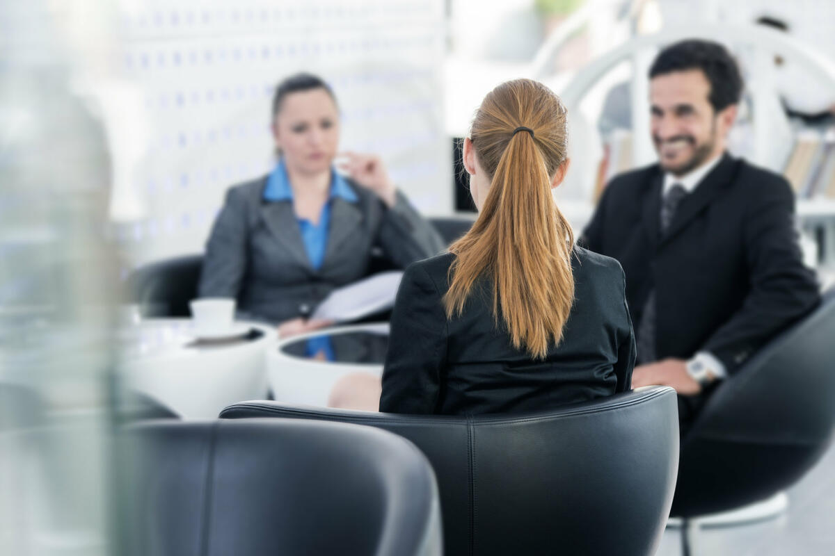 Menschen in Business-Kleidung unterhalten sich in Meeting-Raum © vm / Getty Images