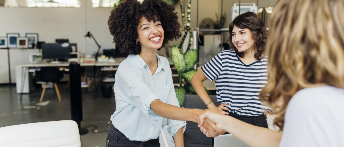 Glückliche Bewerberin schüttelt dem Arbeitgeber im Vorstellungsgespräch die Hand © Westend61 / Getty Images