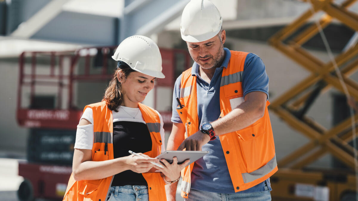 Bauingenieure überprüfen Arbeiten projektgerecht mit digitalem Tablet auf der Baustelle © ilkercelik/ Getty Images