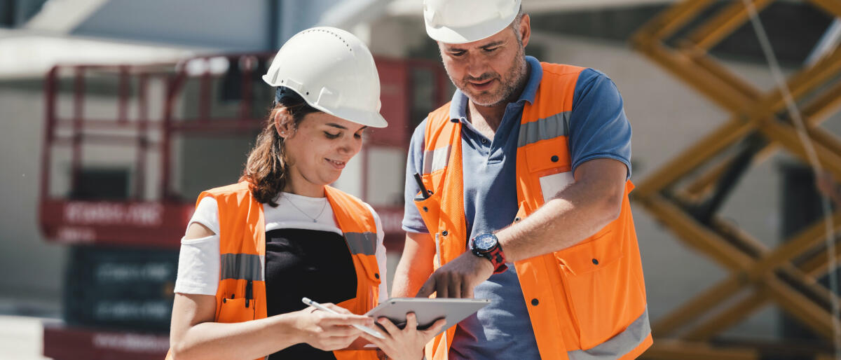 Bauingenieure überprüfen Arbeiten projektgerecht mit digitalem Tablet auf der Baustelle © ilkercelik/ Getty Images