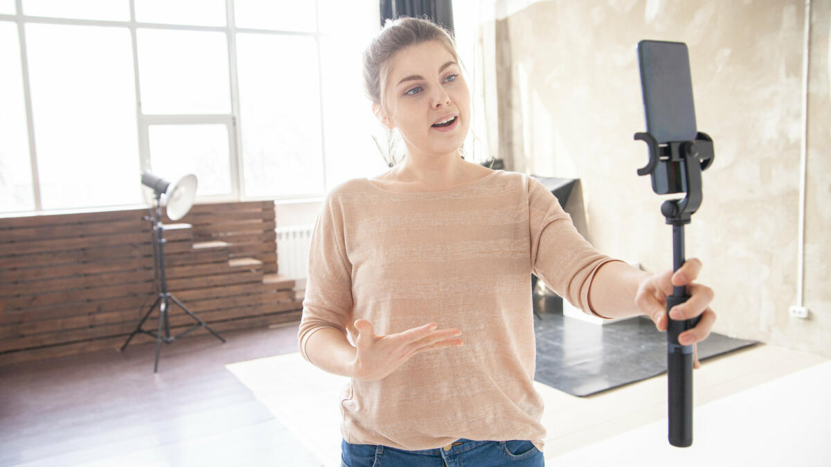 Frau spricht in Smartphone-Kamera. © Iuliia Isaieva / Getty Images