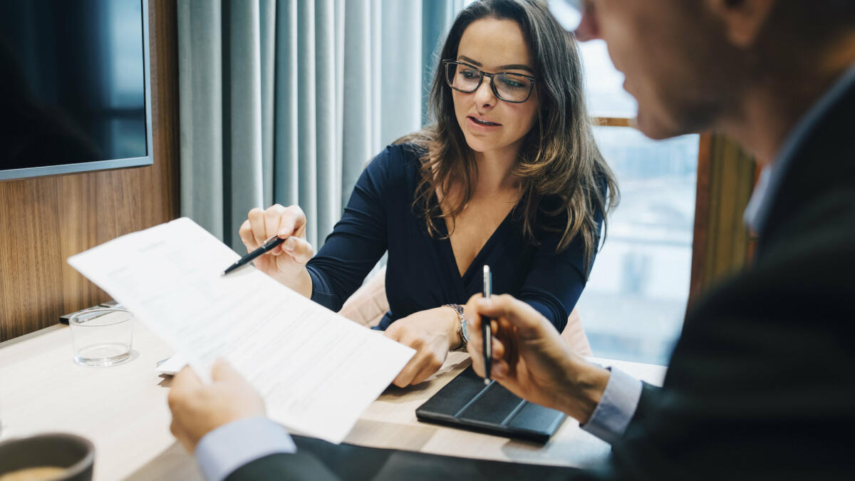 Männliche und weibliche Unternehmer besprechen während eines Treffens im Büro ein Dokument © Maskot / Getty Images