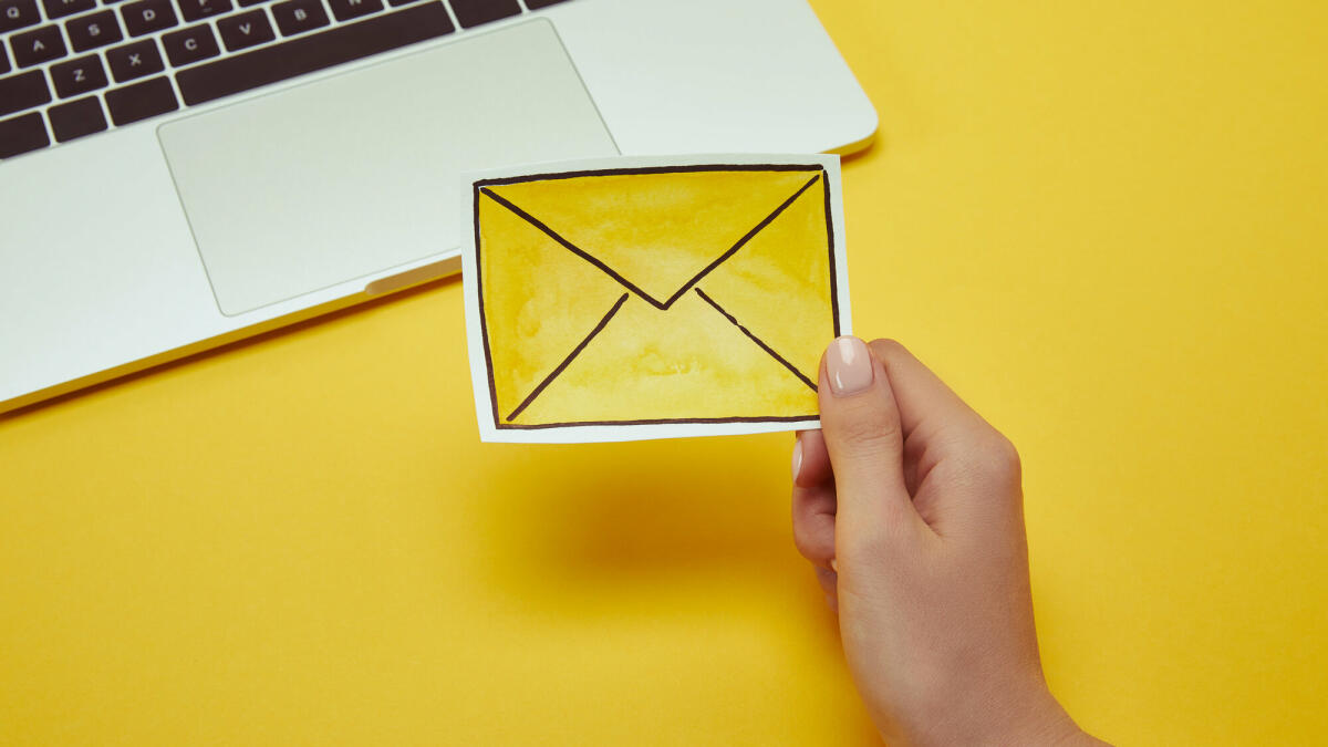 Zugeschnittenes Bild Frau mit Nachricht Schild in der Nähe von laptop © LightFieldStudios / Getty Images