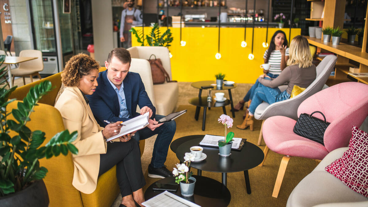 Kaukasischer Geschäftsmann Und Mid Adult Hispanische Geschäftsfrau In Einem Café © AzmanL / Getty Images