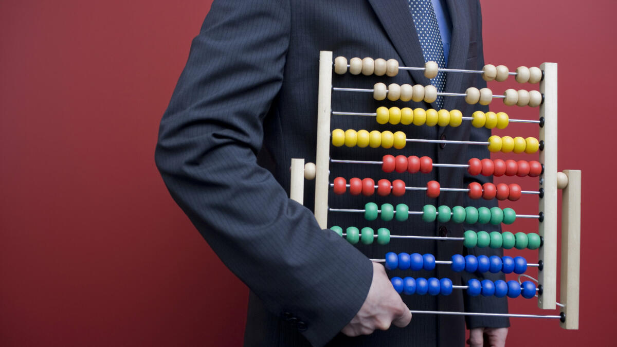 Business-Mann mit einen Abakus-Rechentafel © michellegibson / Getty Images