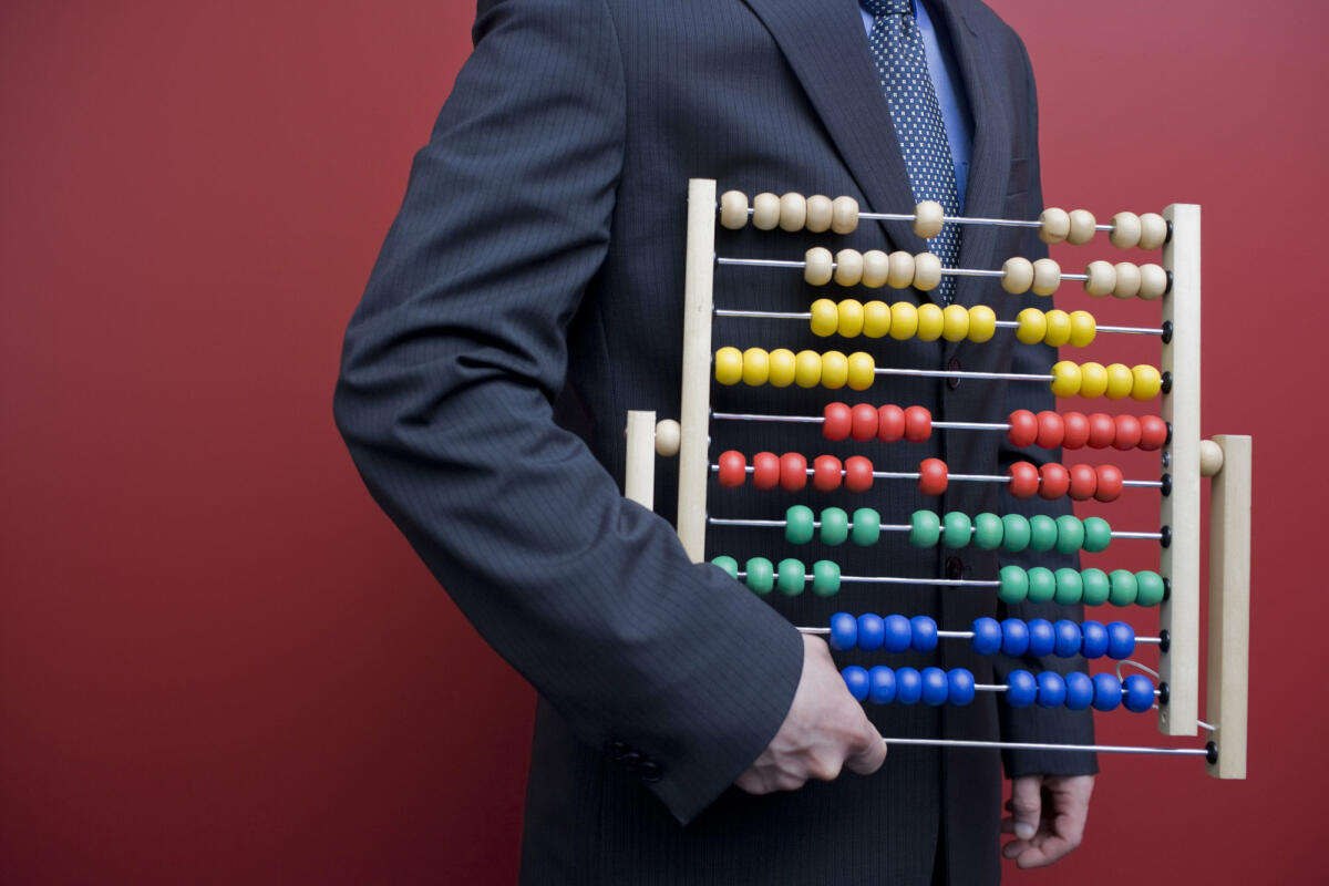 Business-Mann mit einen Abakus-Rechentafel © michellegibson / Getty Images