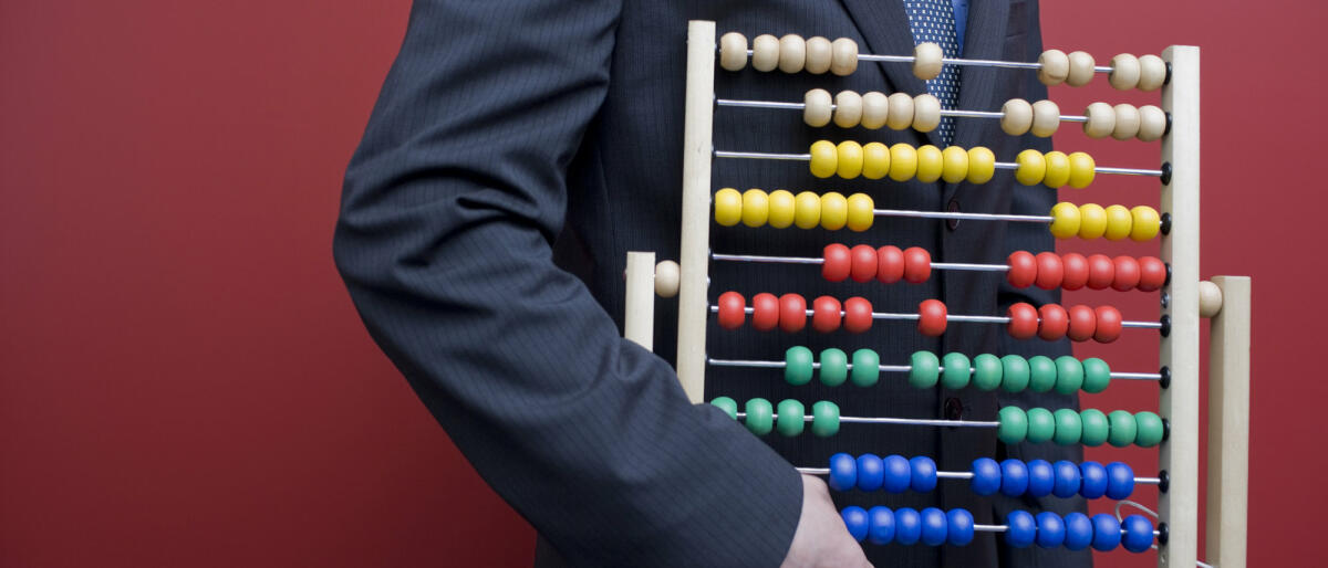 Business-Mann mit einen Abakus-Rechentafel © michellegibson / Getty Images