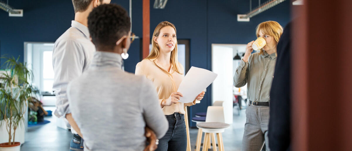 Kreative Gruppe von Geschäftsleuten, die sich in einem modernen Büro treffen. Gruppe von Männern und Frauen sprechen über neue Business-Projekt im Büro. © Getty Images/ 	Luis Alvarez