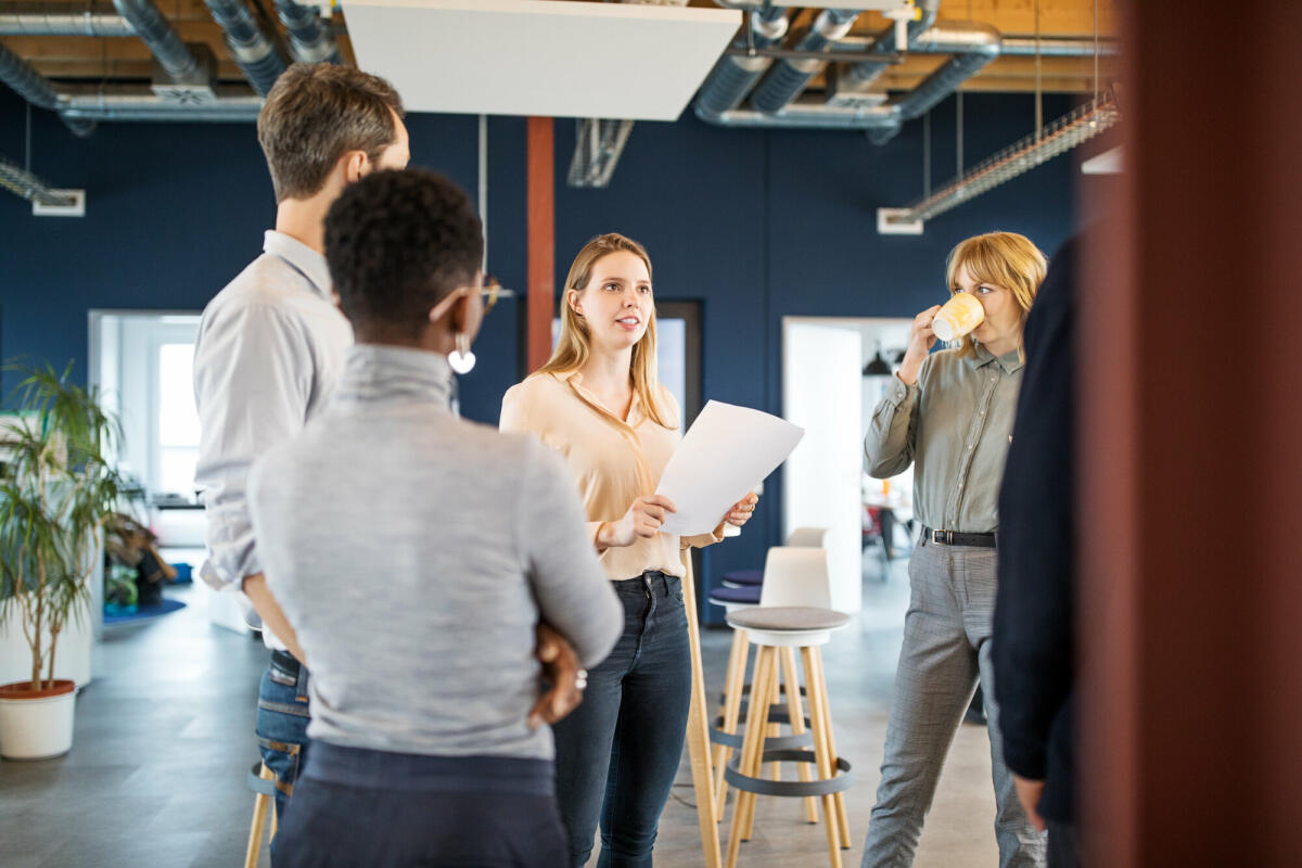 Kreative Gruppe von Geschäftsleuten, die sich in einem modernen Büro treffen. Gruppe von Männern und Frauen sprechen über neue Business-Projekt im Büro. © Getty Images/ 	Luis Alvarez