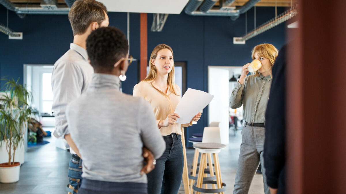 Kreative Gruppe von Geschäftsleuten, die sich in einem modernen Büro treffen. Gruppe von Männern und Frauen sprechen über neue Business-Projekt im Büro. © Getty Images/ 	Luis Alvarez