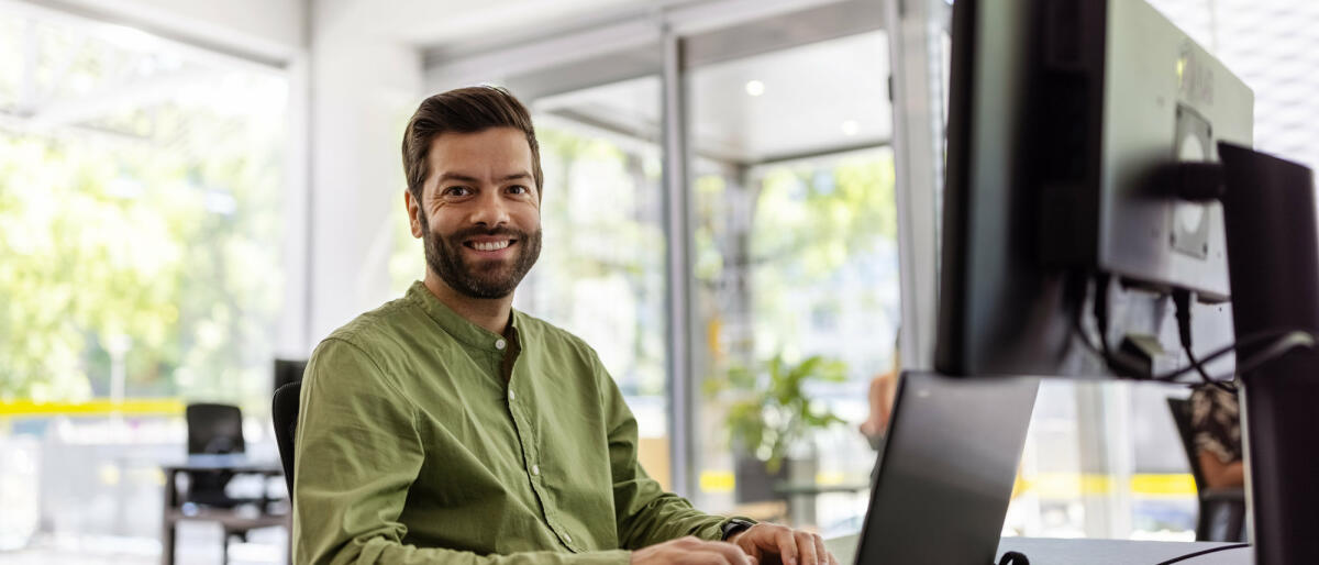 Mittlerer erwachsener Mann sitzt am Schreibtisch und arbeitet am Laptop. © Luis Alvarez / Getty Images