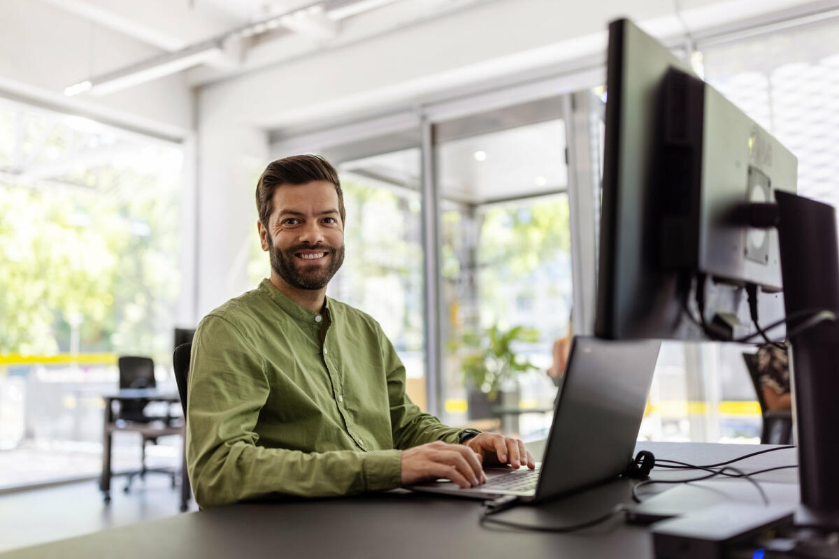 Mittlerer erwachsener Mann sitzt am Schreibtisch und arbeitet am Laptop. © Luis Alvarez / Getty Images