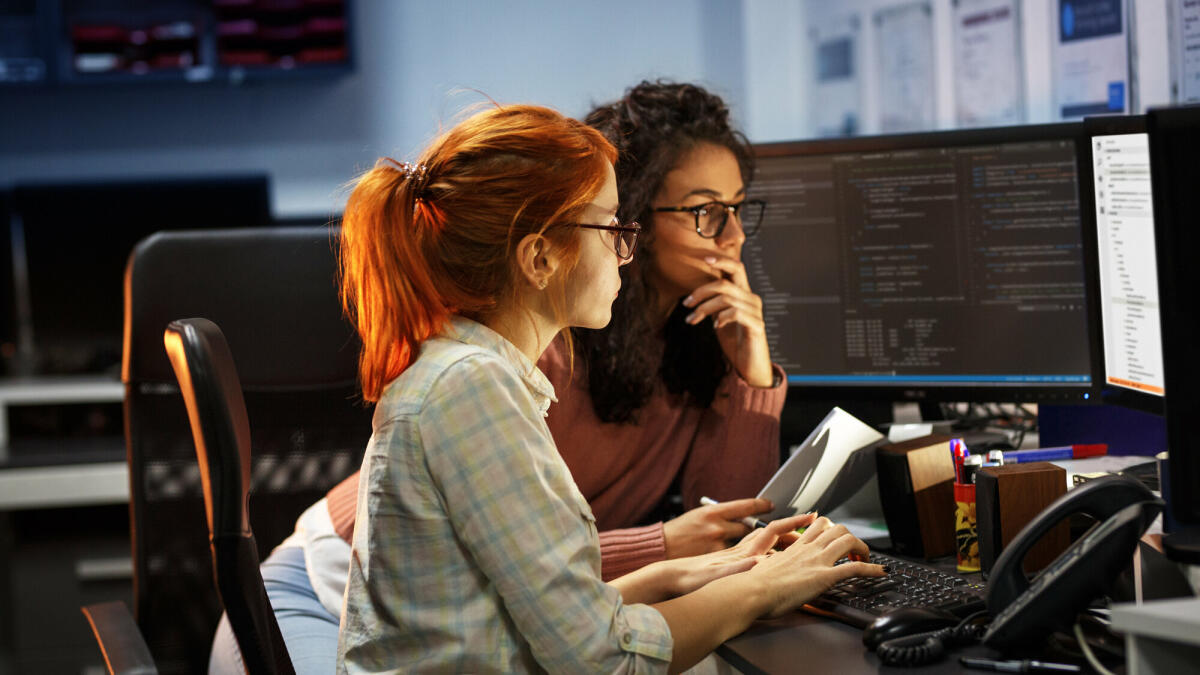 Zwei Programmiererinnen arbeiten an einem neuen Projekt. Sie arbeiten spät in der Nacht im Büro.  © BalanceFormcreative/ Getty Images