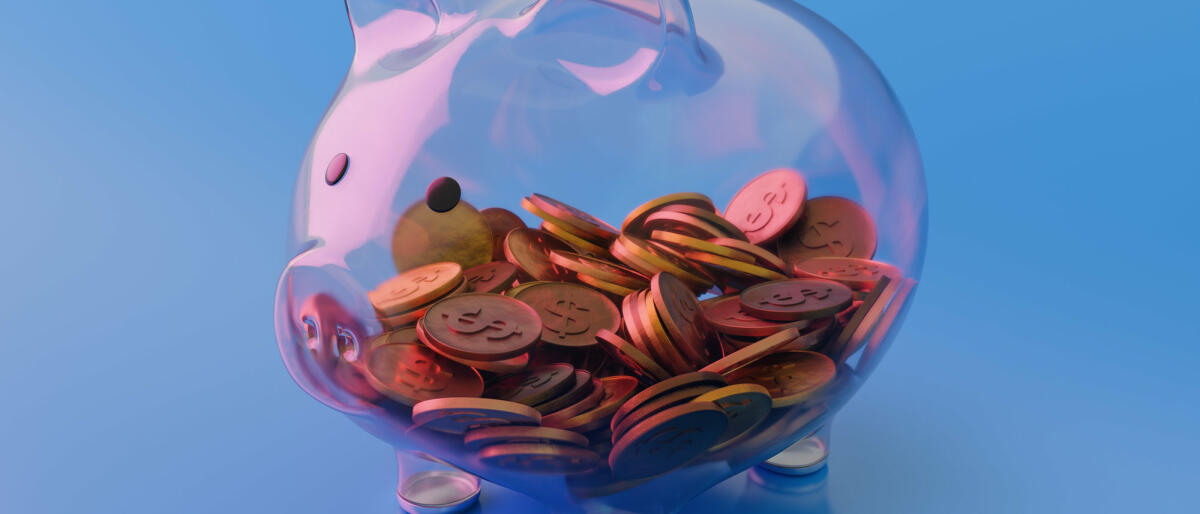 Sehen Sie durch transparentes Glas Sparschwein mit Münzen auf blauem Hintergrund © Constantine Johnny / Getty Images