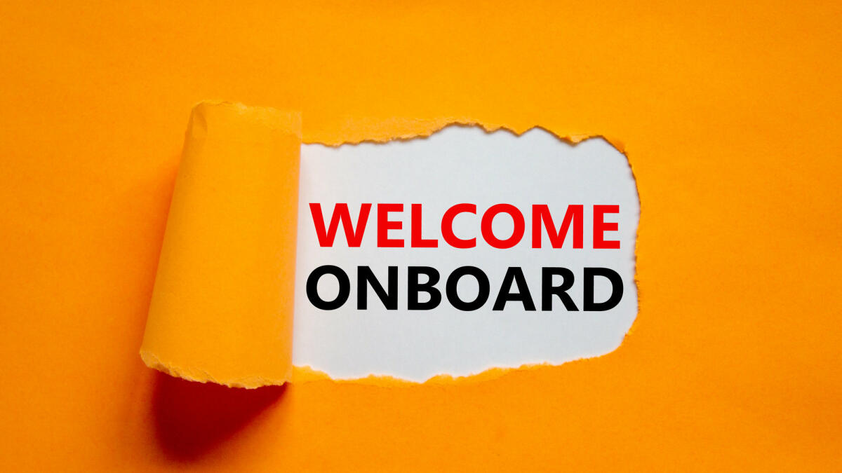 "Welcome Onboarding" vor orangenem Hintergrund © Dzmitry Dzemidovich / Getty Images