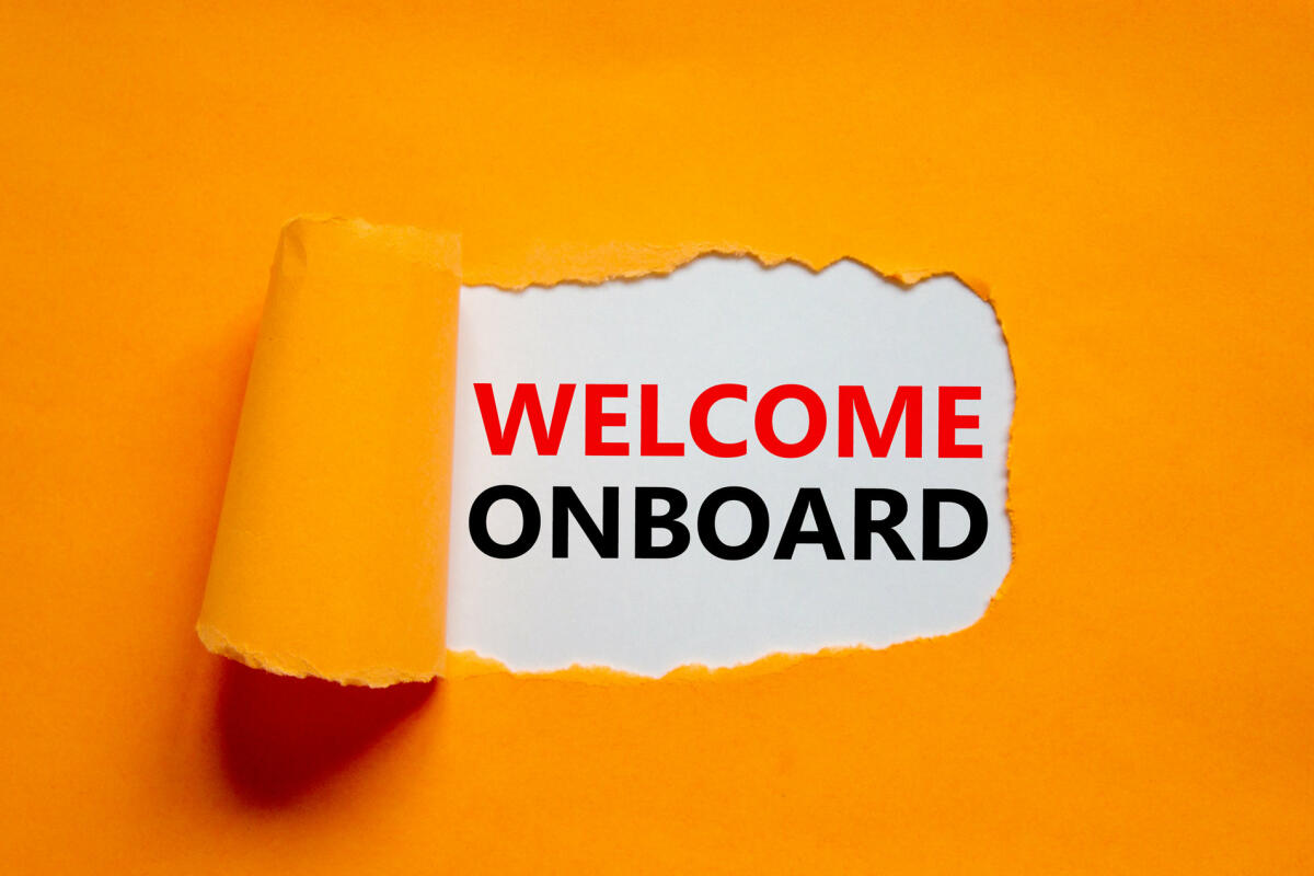 "Welcome Onboarding" vor orangenem Hintergrund © Dzmitry Dzemidovich / Getty Images