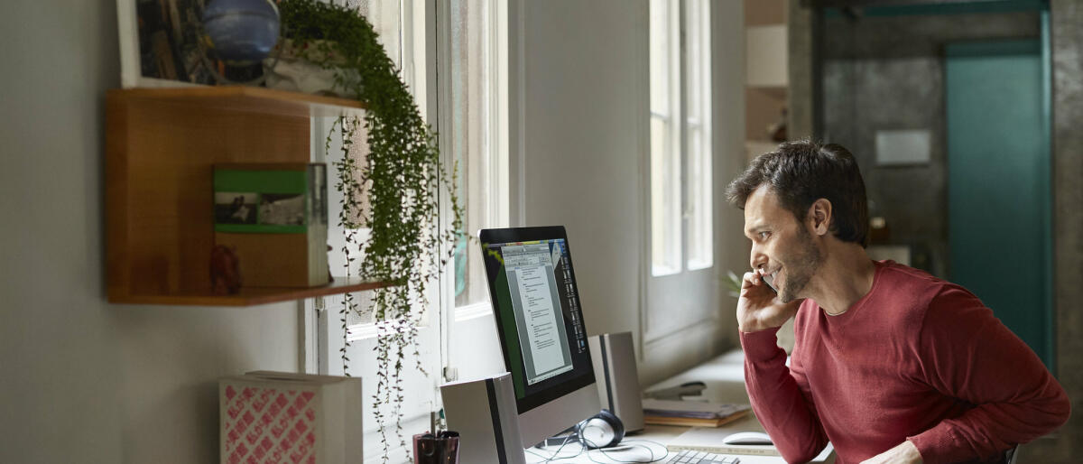 Mann sitzt am Schreibtisch im Homeoffice und telefoniert.  © Morsa Images / Getty Images