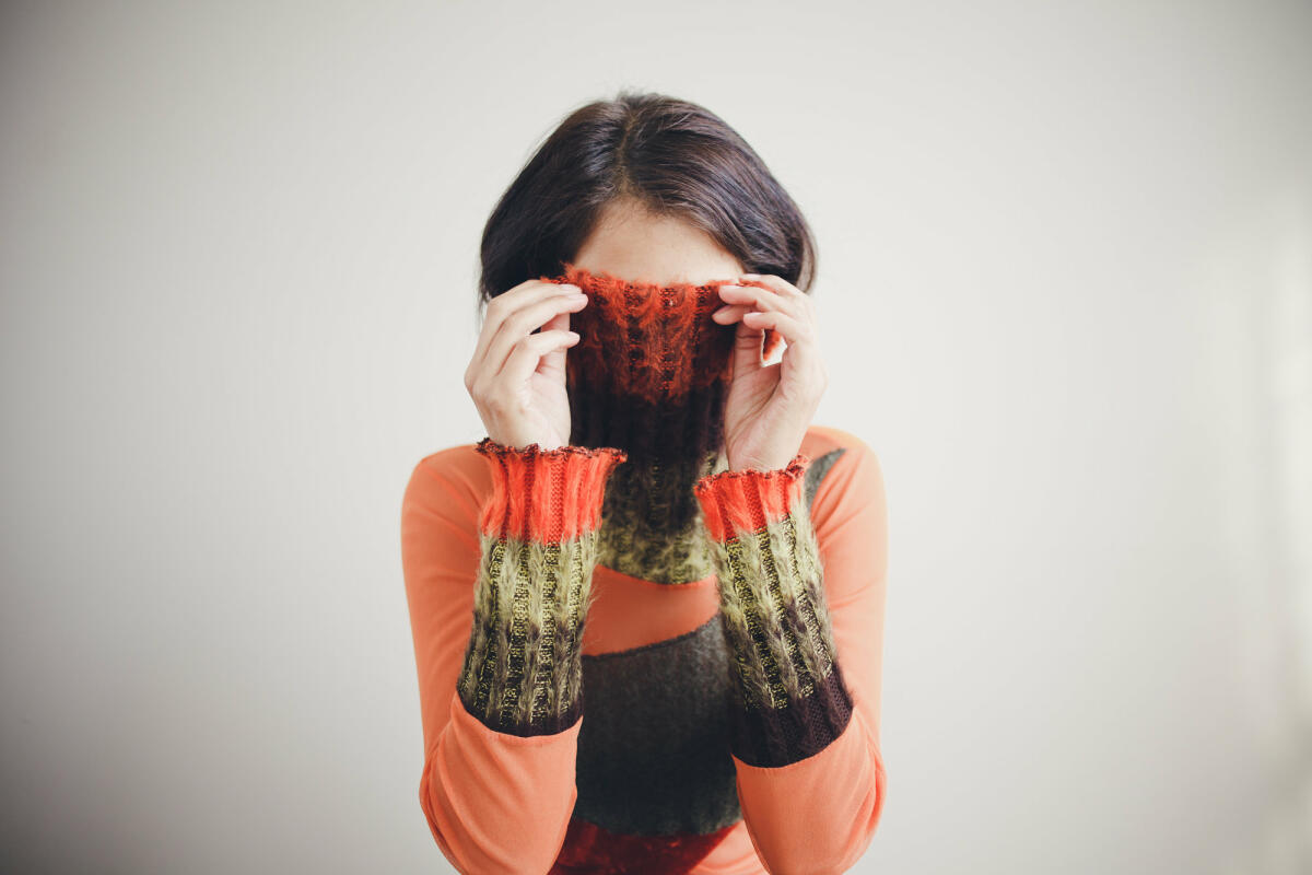 Frau zieht Rollkragen übers Gesicht © Christin Lade / EyeEm / Getty Images