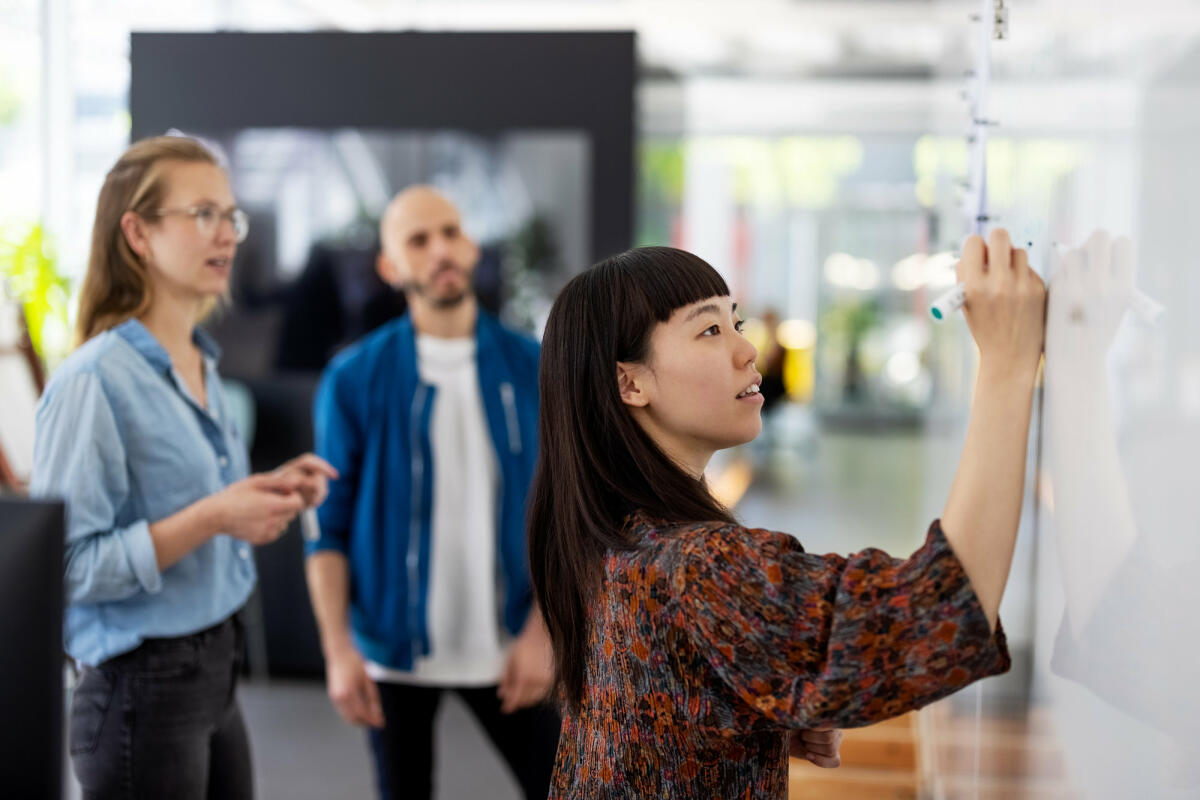 Frau steht am Whiteboard  © Luis Alvarez / Getty Images 