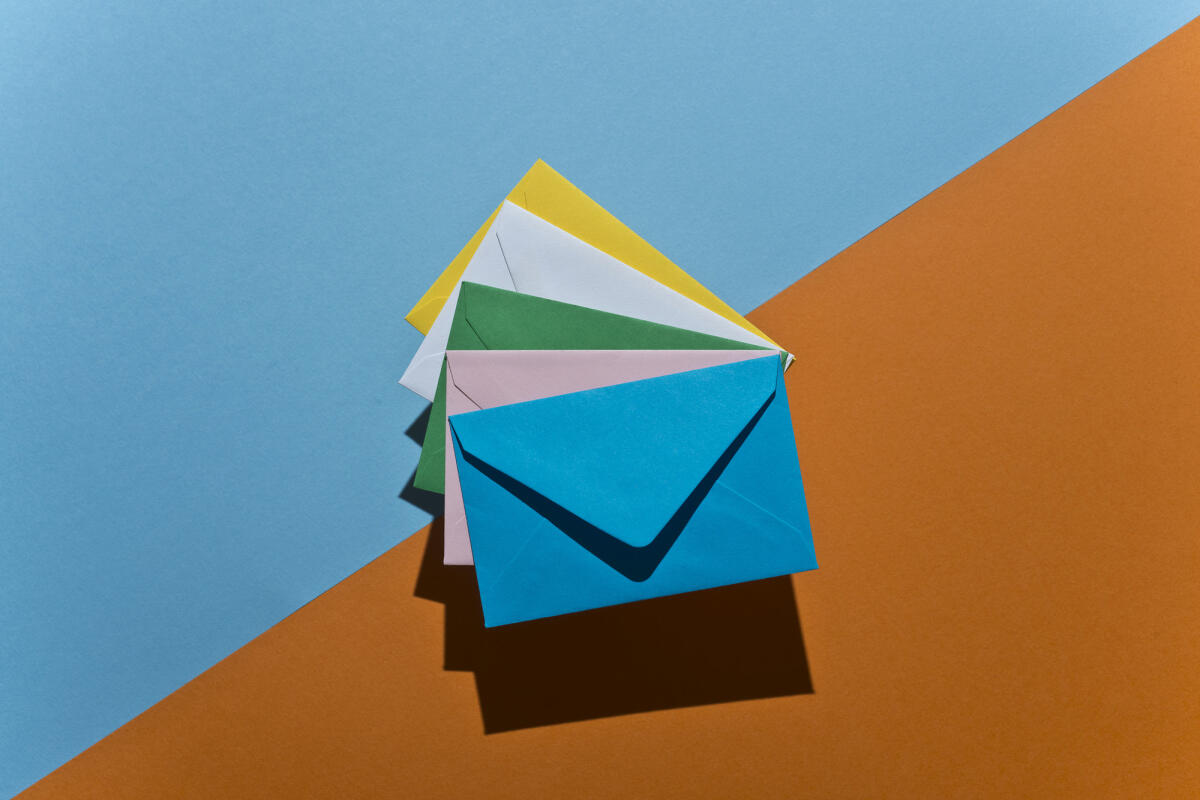 Ein Stapel von farbigen Umschläge auf bicolors Papier Hintergrund © Francesco Carta fotografo / Getty Images