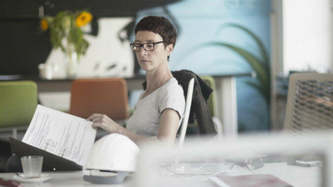 Frau sitzt am Schreibtisch und lies Dokumente © Sigrid Gombert / Getty Images