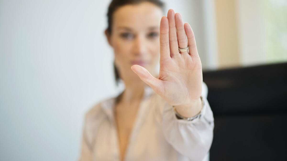 Eine Frau streckt ihre Hand abwehrend nach vorne © Eric Audras / Getty Images