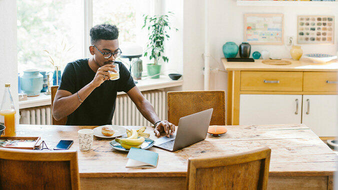 Mann mit Glas in der Hand vor dem Laptop © Maskot / Getty Images