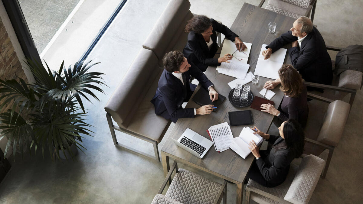 Ein Team von Anwälten plant mit Geschäftskollegen während einer Besprechung in einer Anwaltskanzlei. © Getty Images/ 	Maskot