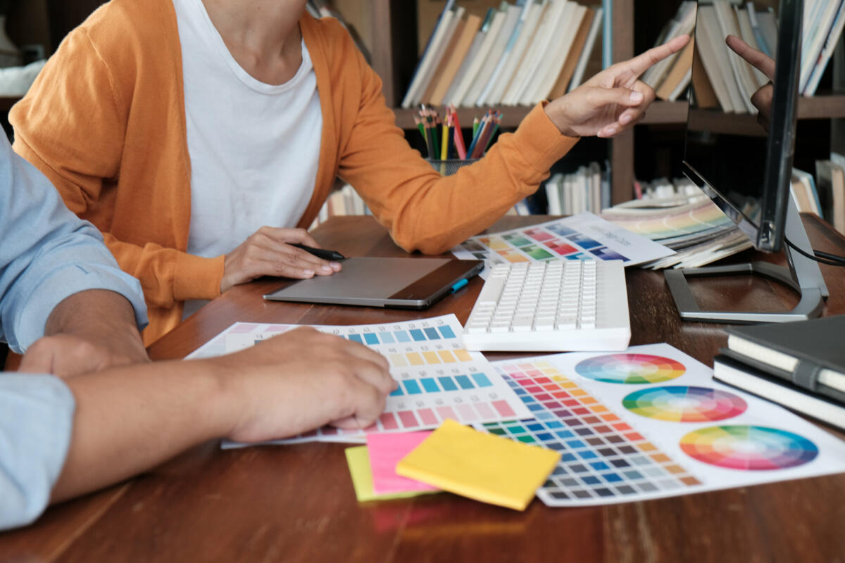 Grafikdesigner, der an einem digitalen Tablet arbeitet. Künstlerzeichnung auf Grafiktabletts und Farbmustermustern. © Dacharlie/ Getty Images