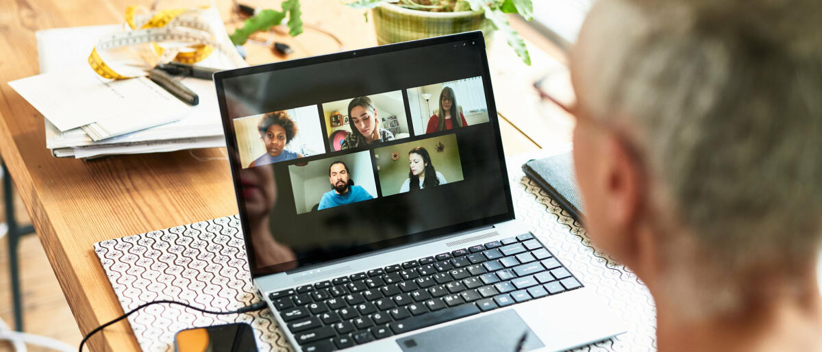 Mann sitzt vor Laptop mit Videokonferenz. © 10'000 Hours / Getty Images