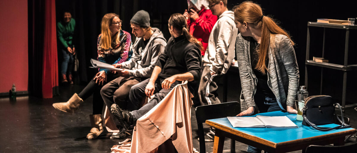 Gruppe von Schauspielern auf der Bühne während der Theateraufführung. © CasarsaGuru/ Getty Images