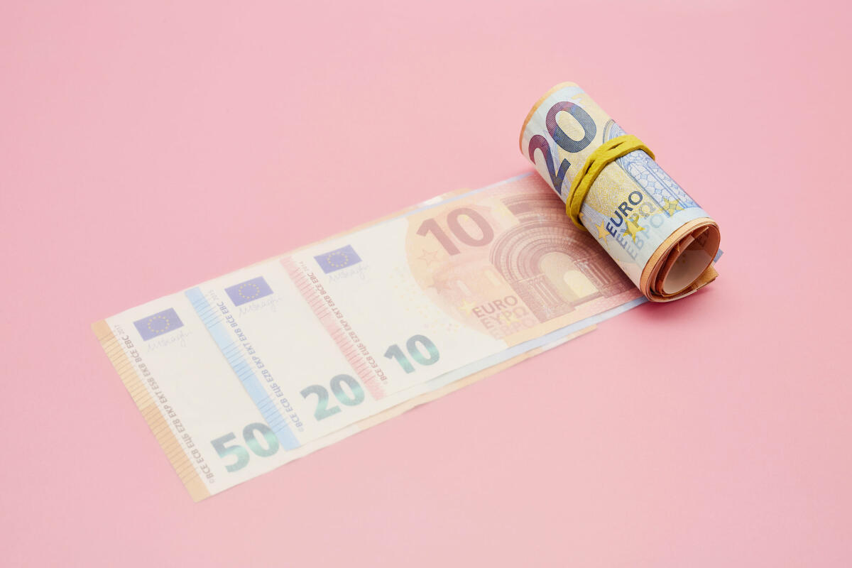 Eine Rolle von Euro Banknoten vor pinkem Hintergrund © the_burtons / Getty Images