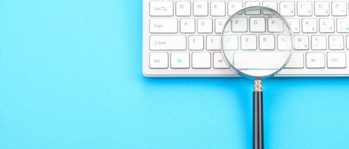 Vergrößerungsglas auf einer Tastatur © jayk7 / Getty Images