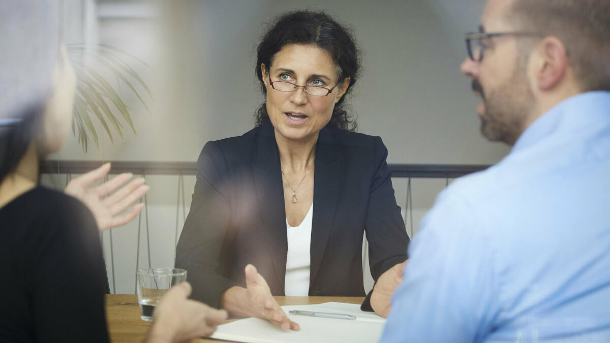 Eine mittelreife Anwältin berät ihre Mandanten © Maskot / Getty Images