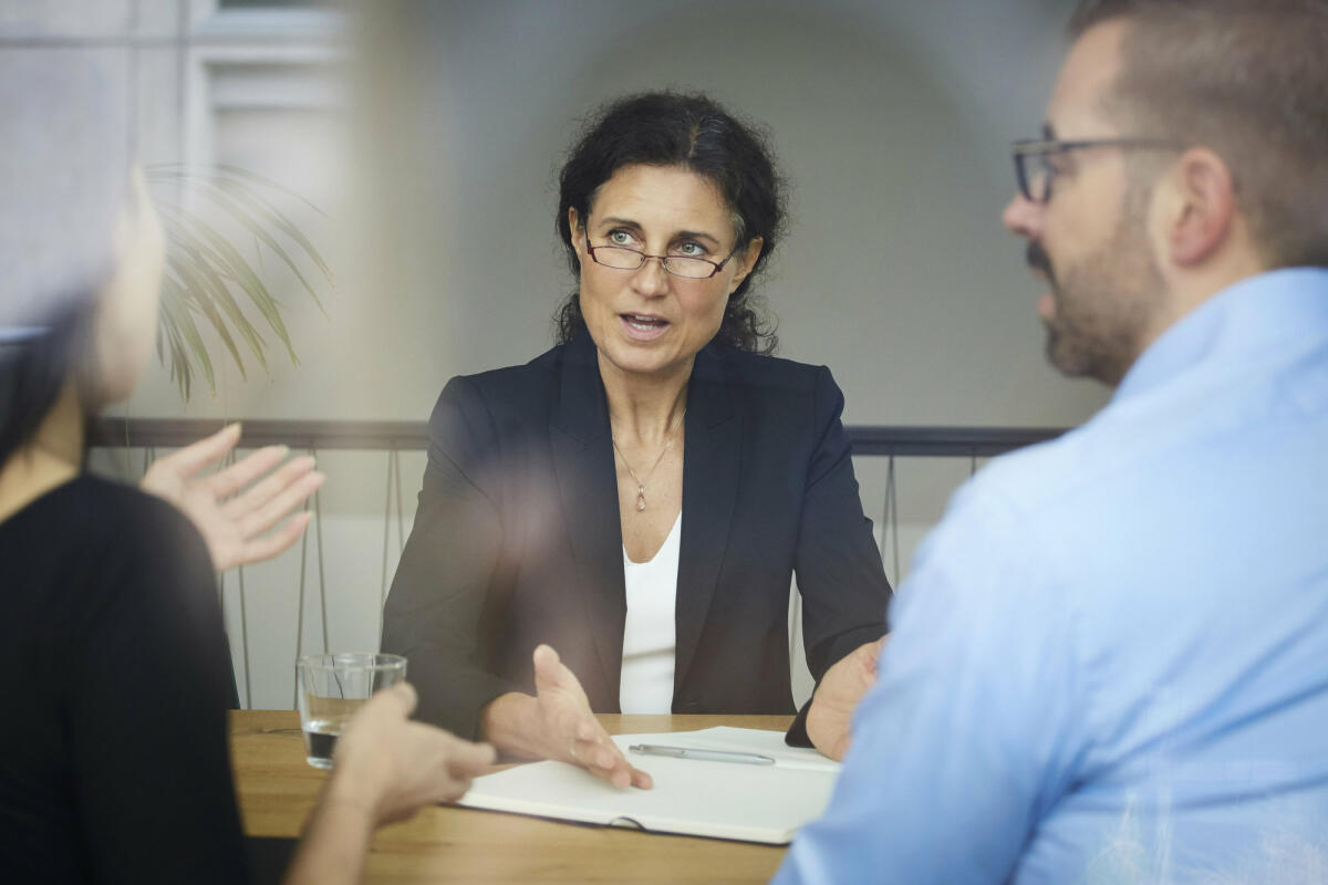 Eine mittelreife Anwältin berät ihre Mandanten © Maskot / Getty Images