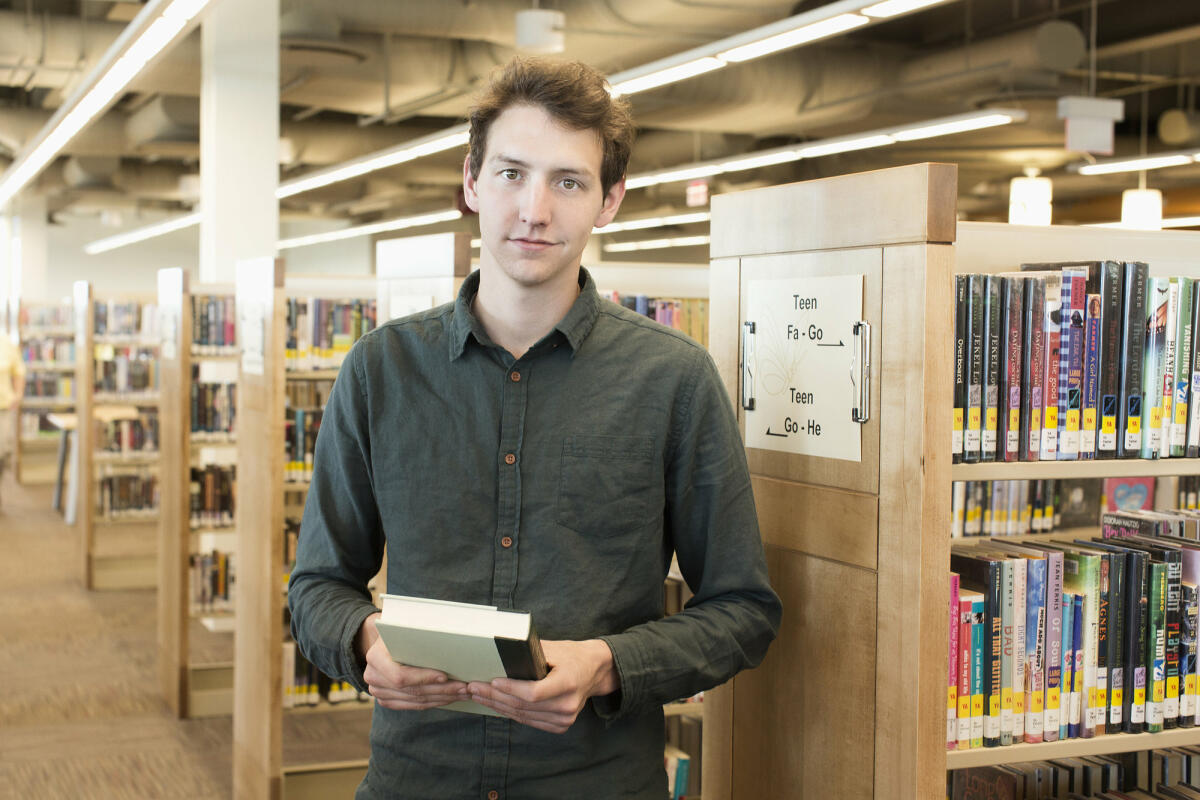 Bibliothekar, der ein Buch hält © Hill Street Studios / Getty Images