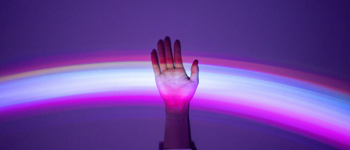 Hand, die sich meldet und in einem lila Lichtspiel aufleuchtet © Qi Yang / Getty Images